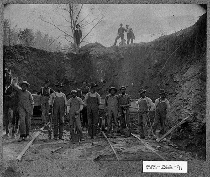 "Macon area, ca. 1900. Members of a chain gang pose for the camera while working in a pit with a mule and sled while the overseers look on."--from field notes